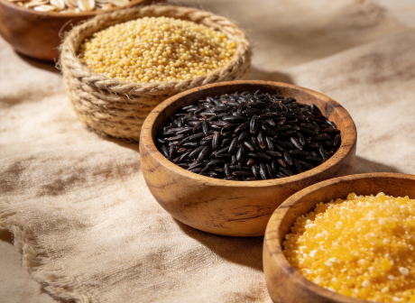 Raw multigrain mix of oats, millet, black rice and corn grits in wooden bowls